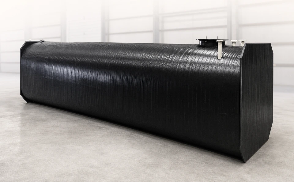 A black rectangular tank laying sideways in an empty room